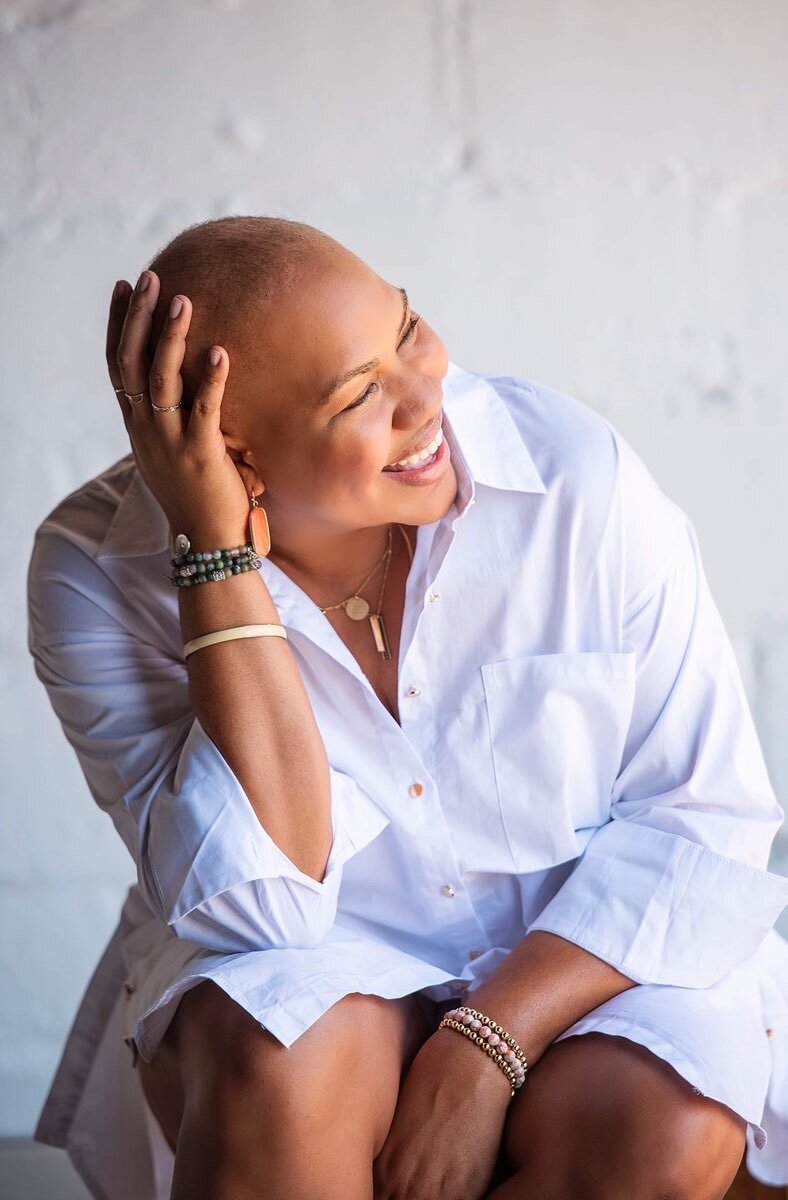 Breast cancer survivor Angie McPherson smiling and embracing her bald head with confidence