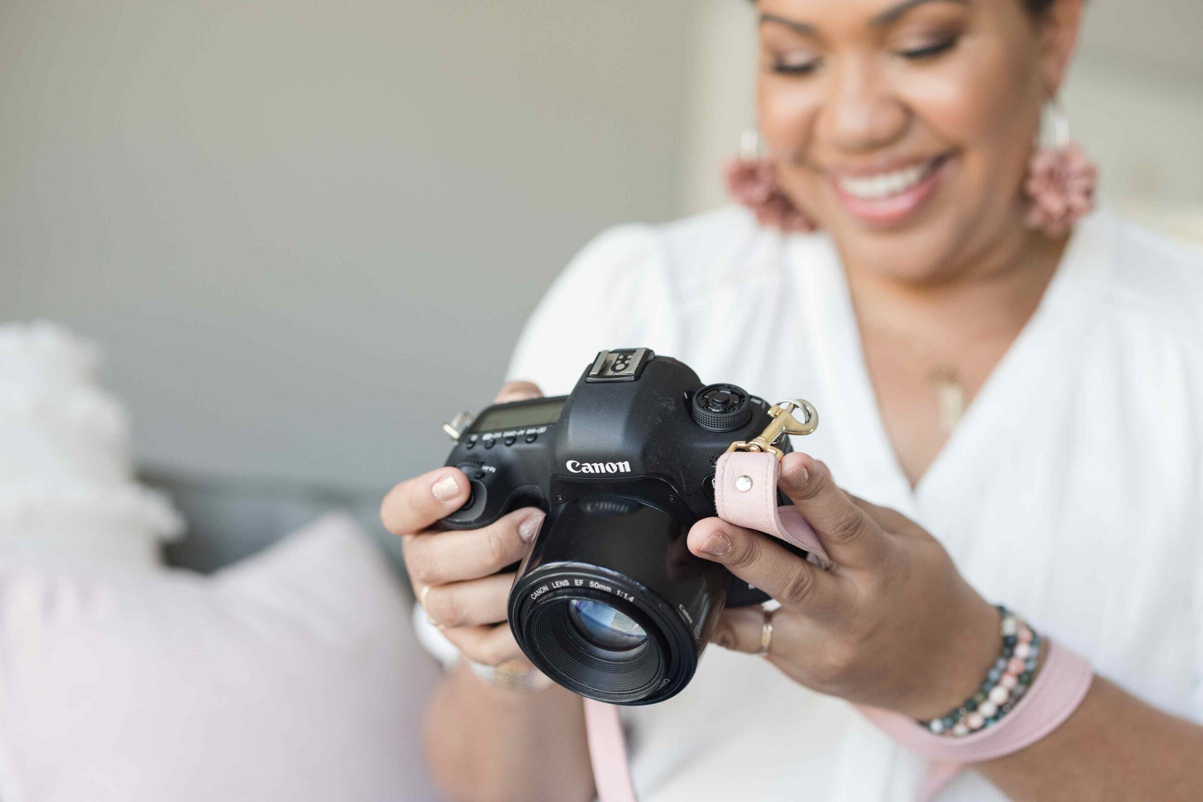Branding photographer and coach, Angie, with camera, illustrating tips on how to raise branding photography prices